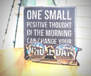 pair of glasses and a sign one small thought in the morning can change your whole day
